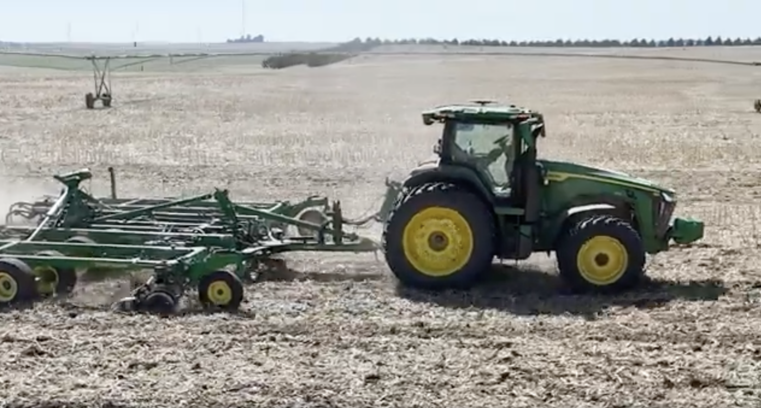 Autonomous John Deere tractor in a planting field.